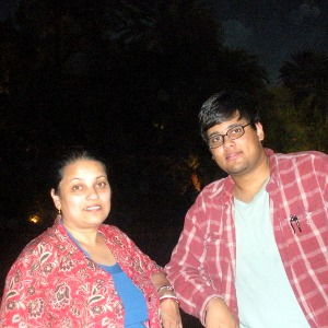 Photo of Pinaki and his mother standing in front of palm trees.